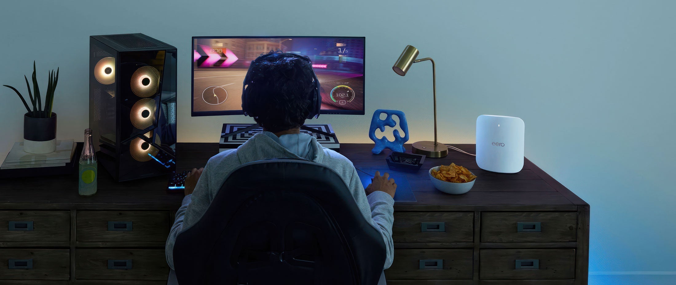 A boy playing video games at his desk.
